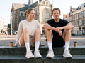 Twee hardlopers met koffie op de Grote Markt, CALFTALK sokken