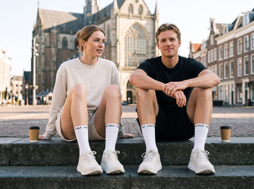 Twee hardlopers met koffie op de Grote Markt, CALFTALK sokken